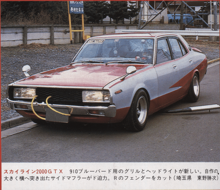 Vintage car with custom front grille and bold side exhaust on a street background.