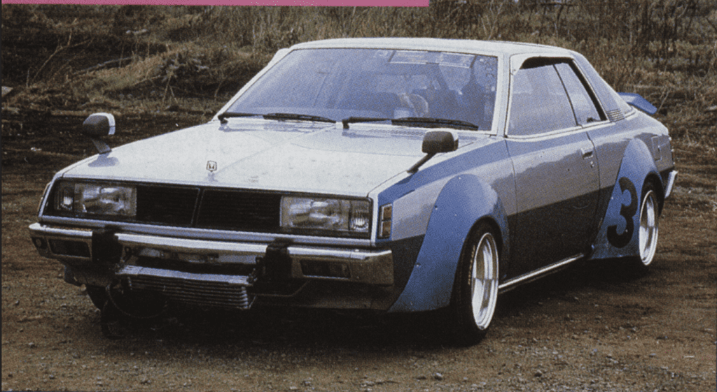 Vintage blue race car parked on dirt, with number 3 on side. Classic design and custom modifications visible.