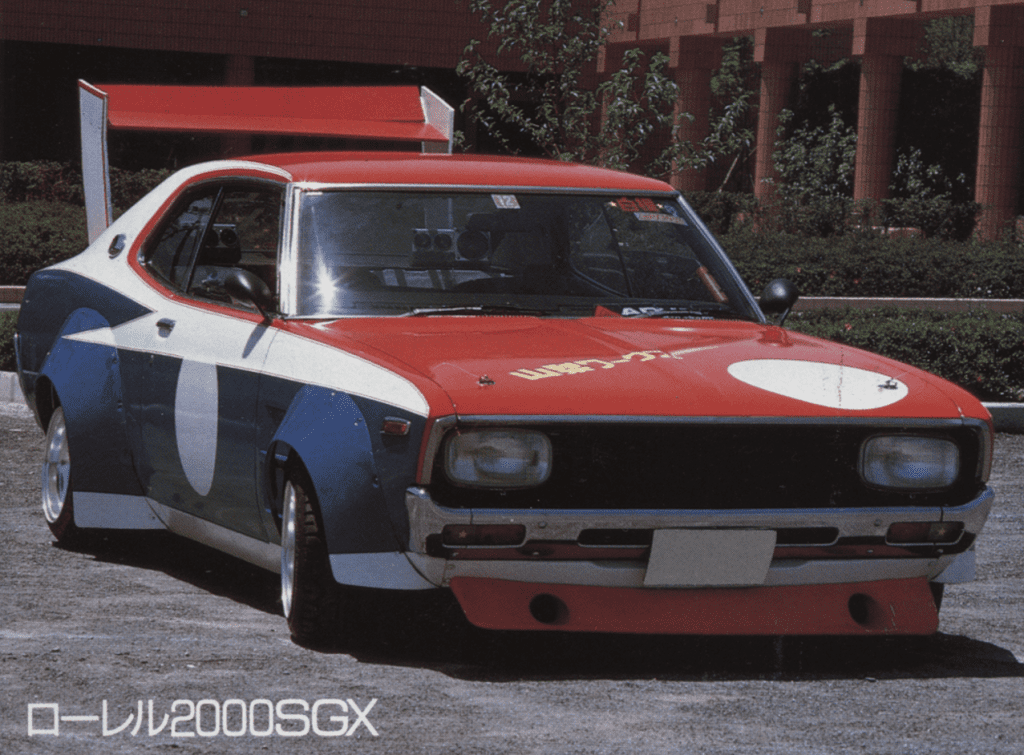 Vintage Nissan Laurel 2000SGX in red, white, and blue paint parked outdoors.