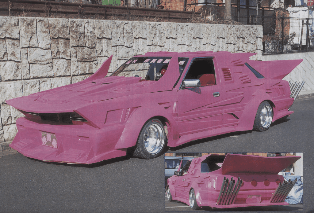 Custom pink car with exaggerated body kit and rear fins, showcasing bold design and unique street style.