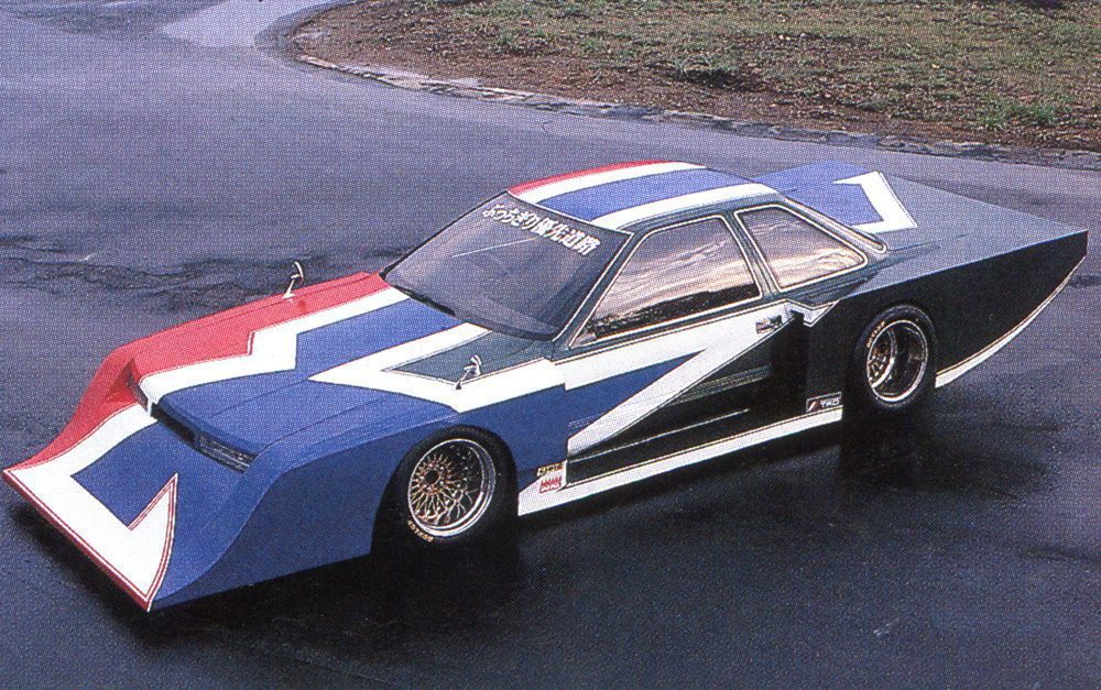 Futuristic custom car with bold red, blue, and white geometric designs on pavement.