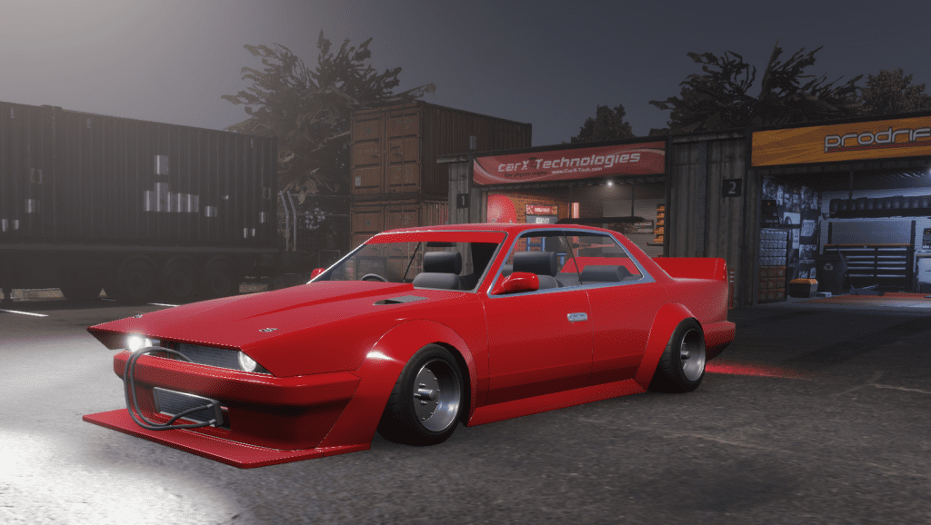 Red sports car parked at night, in front of garage workshops, showcasing sleek aerodynamic design and modifications.