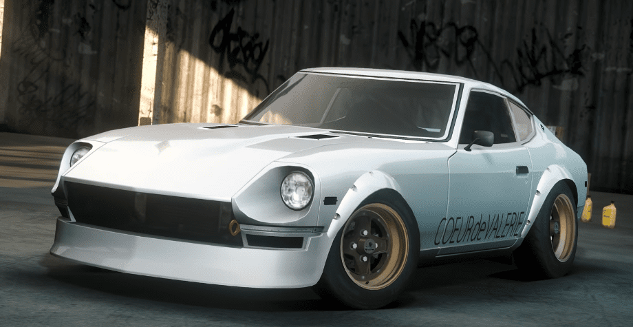 Classic white sports car with custom rims parked in an industrial setting, graffiti visible on the background wall.