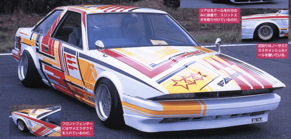 Retro modified car with vibrant geometric decals and wide wheels on a track.