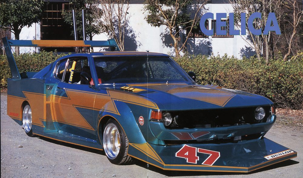 Vintage Toyota Celica race car with bold graphics and number 47 displayed outdoors.