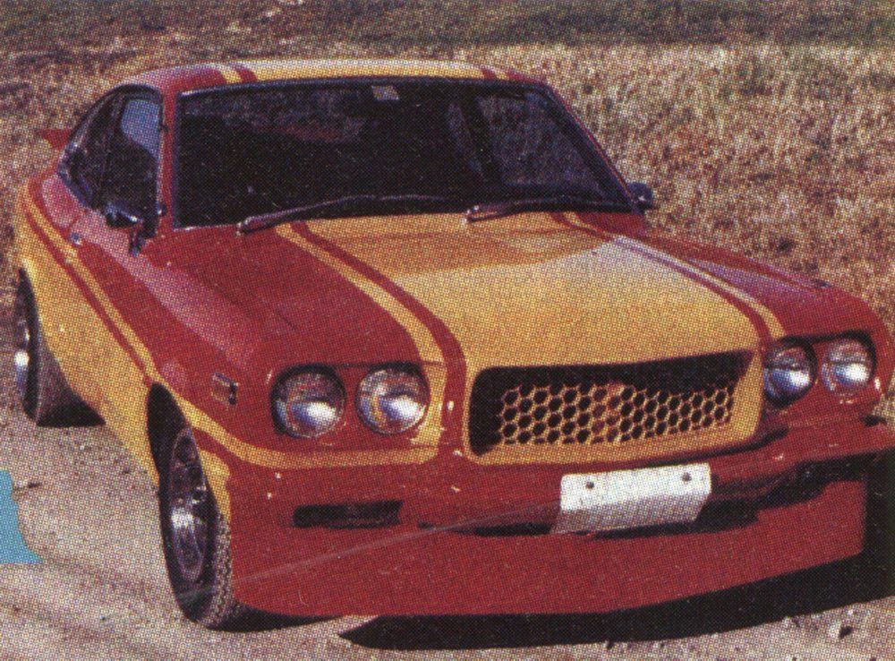 Vintage yellow and red classic car with racing stripes parked outdoors.