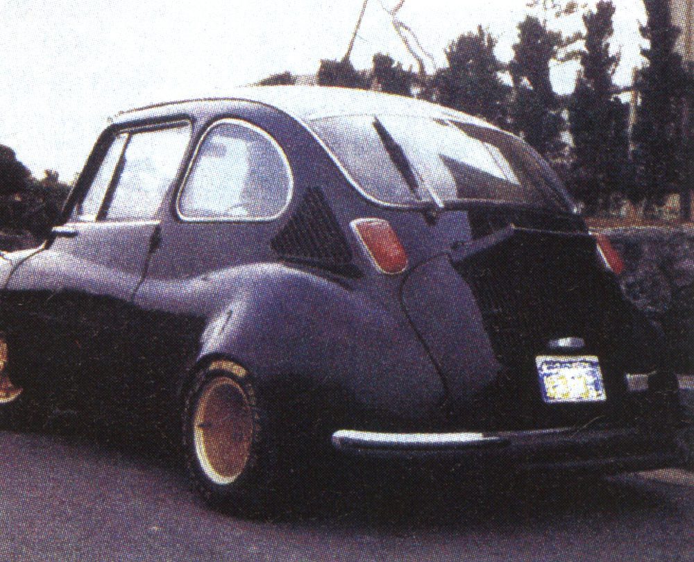 Vintage compact car parked on street, showcasing retro design and classic curves.