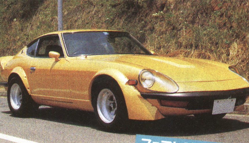 Vintage yellow sports car parked on a road, showcasing its classic design and sleek curves.