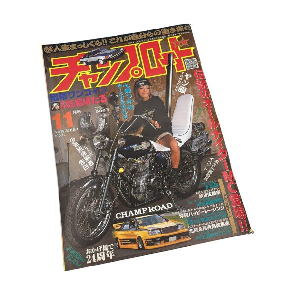 Japanese magazine cover with motorbike and rider, featuring car and vibrant text elements.