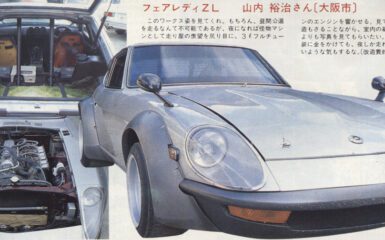Classic sports car with open hood and modified interior, showcasing engine and custom trunk accessories.