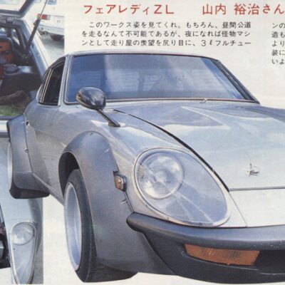 Classic sports car with open hood and modified interior, showcasing engine and custom trunk accessories.