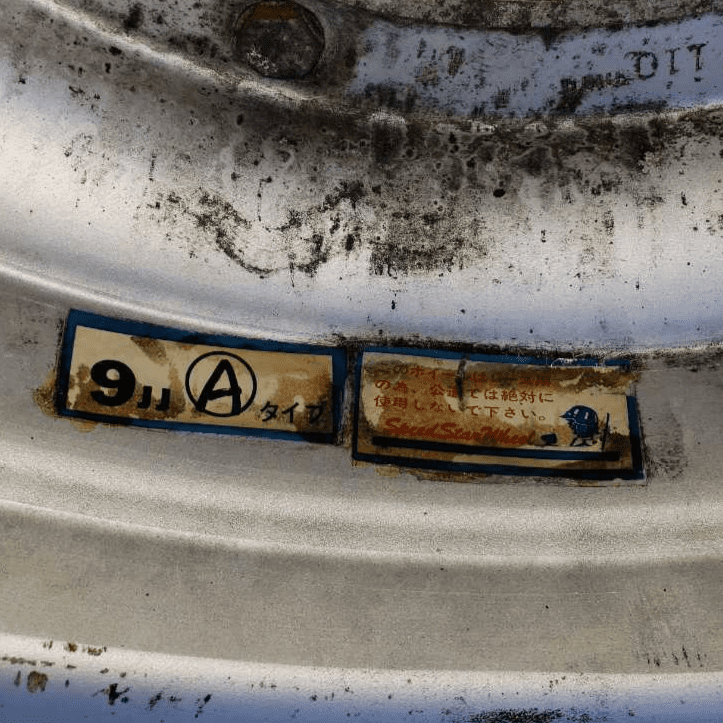 Close-up of a car wheel with Japanese labels showing details and specifications.