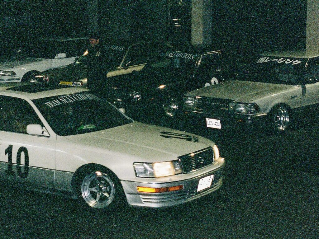 Vintage cars parked in a dimly lit area, showcasing classic style and retro aesthetics at night.