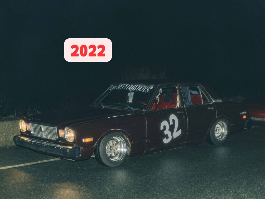 Classic black car with number 32 and Team Sexy Boys sticker parked at night, highlighted by 2022 tag.
