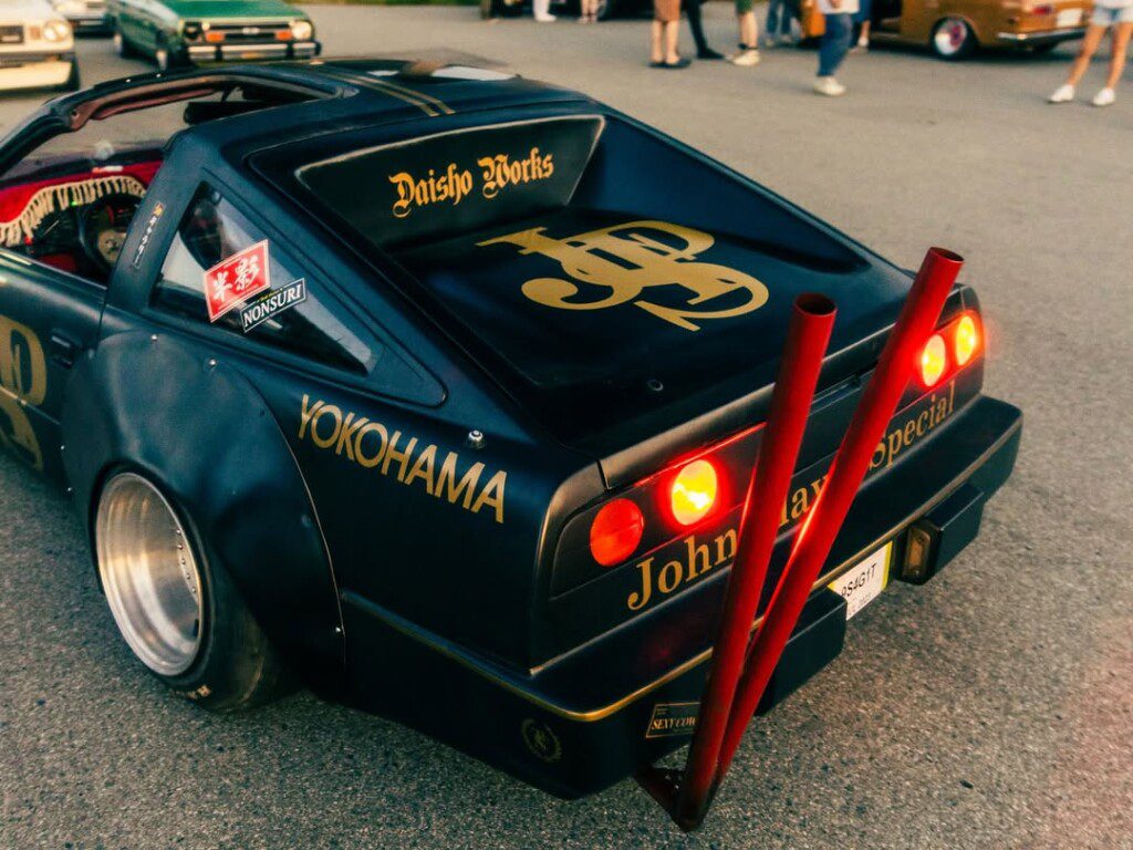 Modified retro car with custom paint and exhausts at a car show, displaying Yokohama branding.